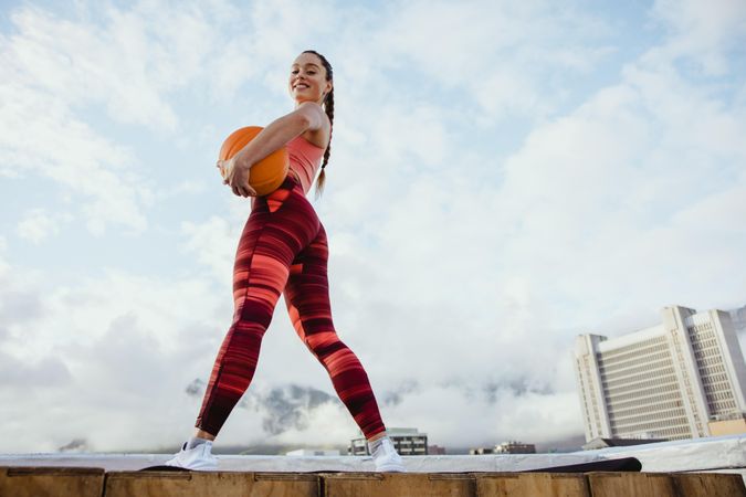 Low angle of sporty woman holding medicine ball