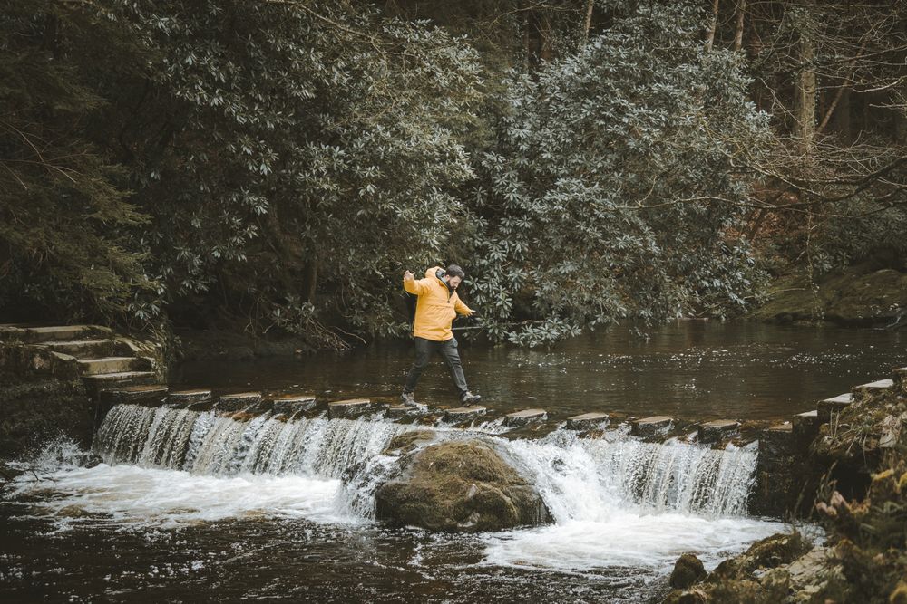 Man crossing river on stepping stones