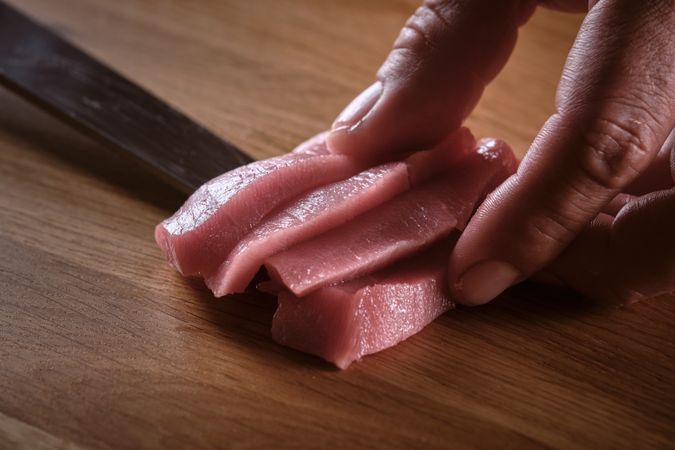 Male hands slicing fresh bluefin tuna loin