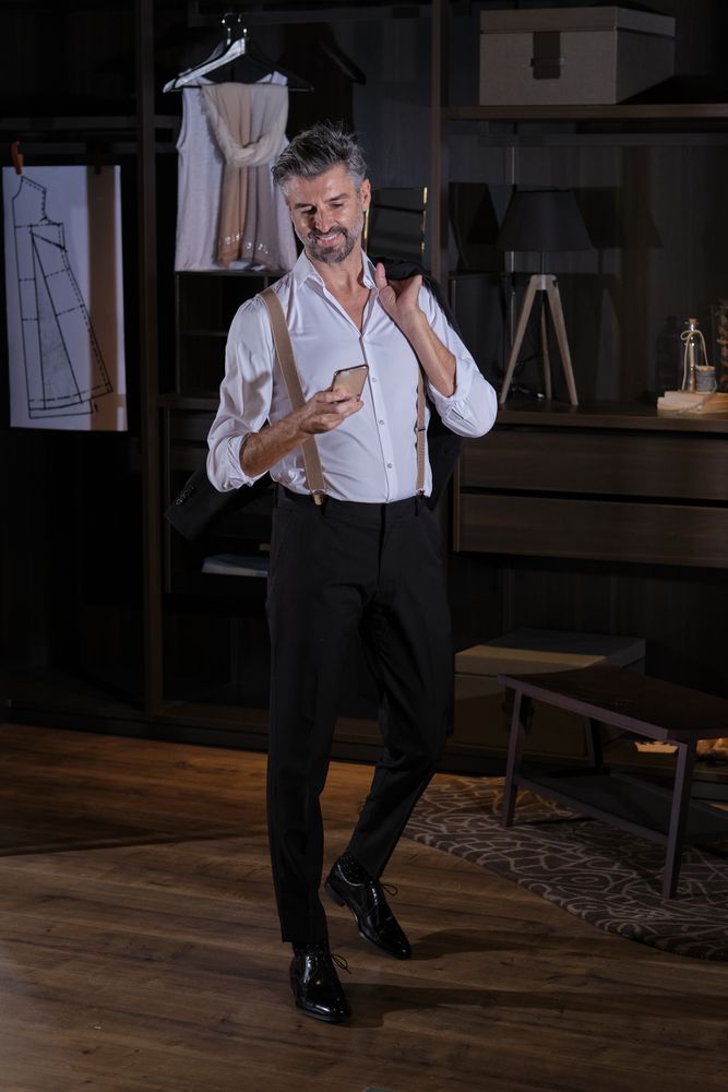 Mature man in elegant suit texting message on smartphone in ward