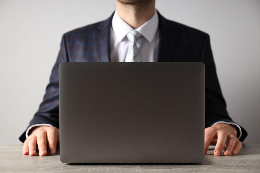 A man in a suit works on a laptop