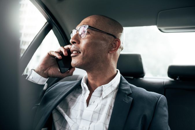 Man managing business on mobile phone sitting in car