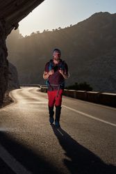 Man with backpack walking on road in mountains