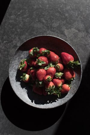 heap of strawberry near plate