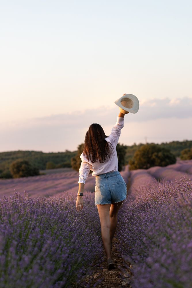 Anonymous woman walking in lavender field