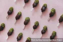 Diagonal rows of ice cream chocolate pistachio popsicles, pink background 0ggY80