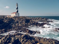 Lighthouse located near wavy sea