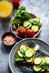 Top view of delicious meal of bread with cucumber slices, tomatoes and Himalayan salt