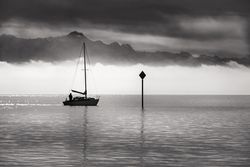 Monochrome image of a single boat sailing
