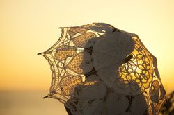 Woman with vintage umbrella at sunset