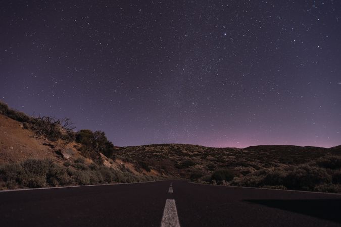 Empty road at night under bright stars