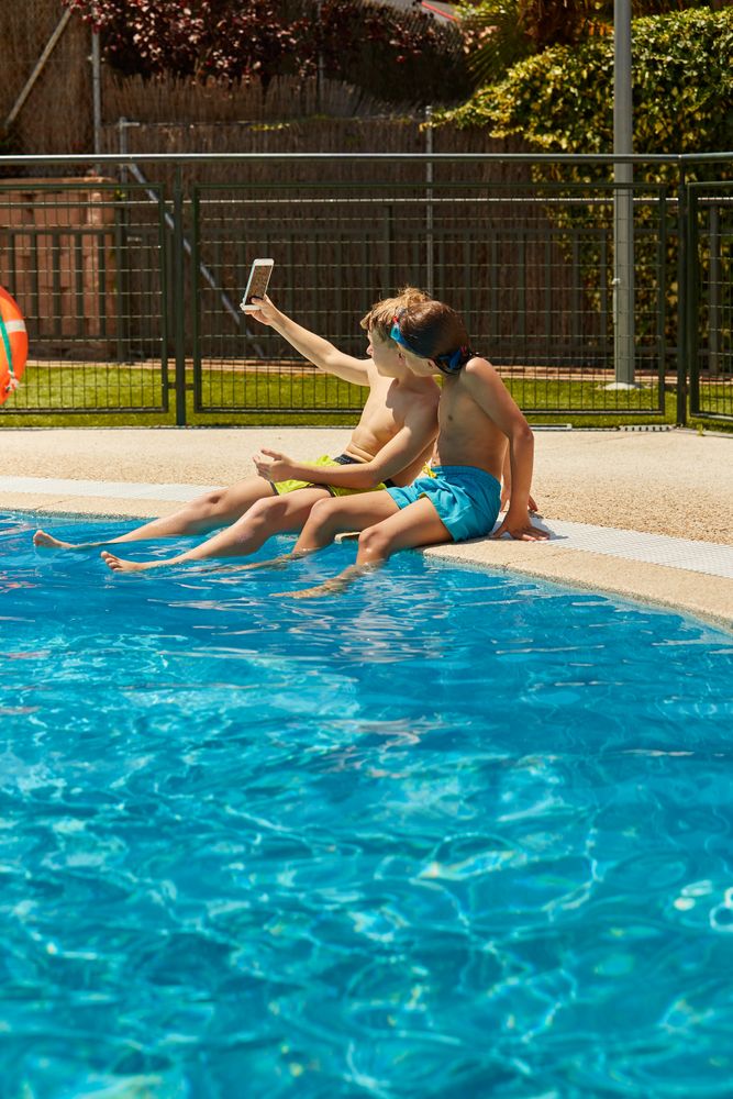 Boys on poolside taking selfie
