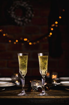 Christmas, New Year festive set, wooden table with glasses of champagne, dinnerware, candles