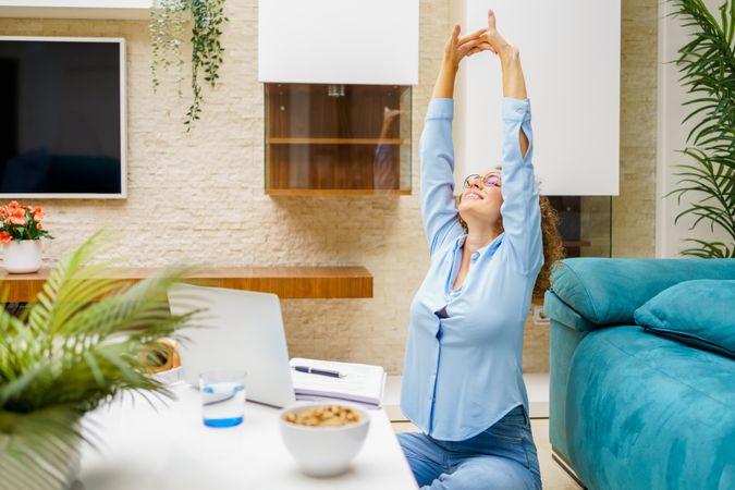 Woman stretching her arms taking a break from laptop