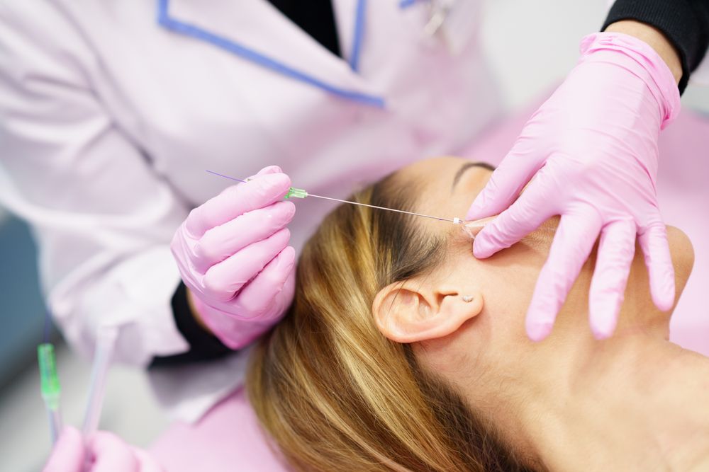 Woman having filler inserted into cheek