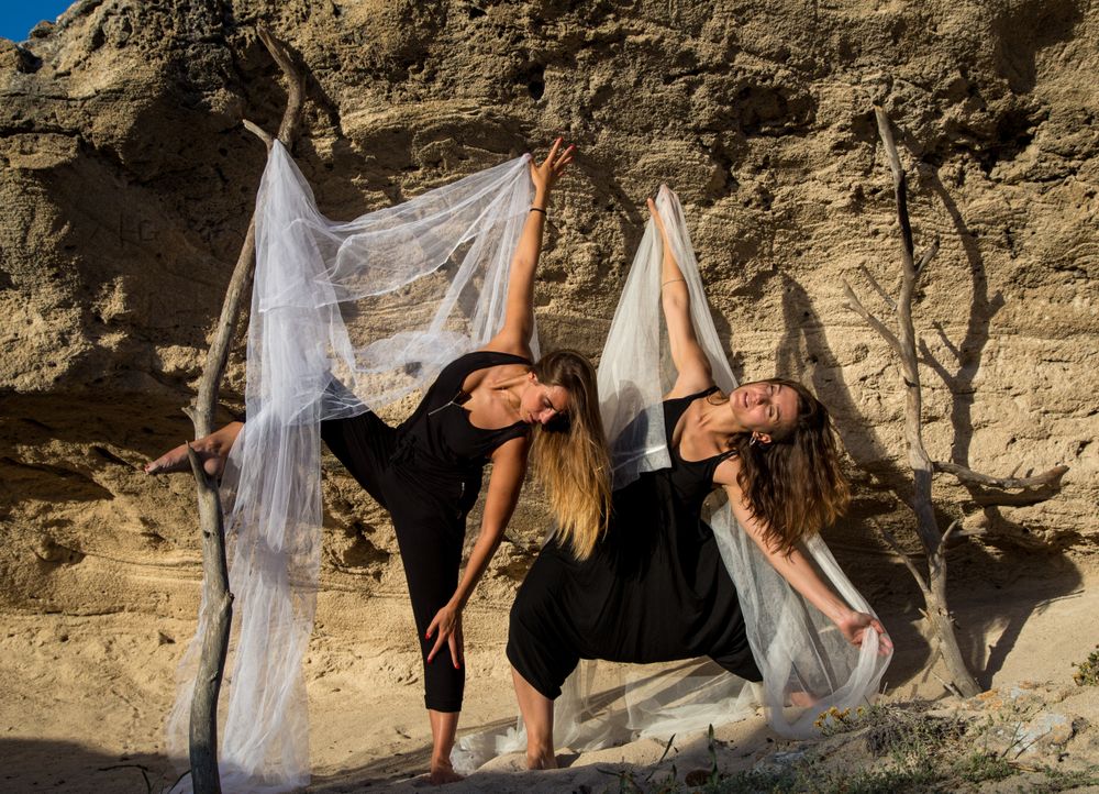 Women with textile dancing near stones