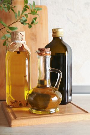 Bottles with oil and plant on kitchen table