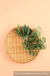 Looking down at thatched basket with different herbs 4ABm8b