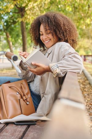 Black woman reading book in park