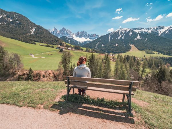 woman admiring the views of Small beautiful village between mountains with snow
