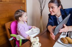 Businesswoman mother and baby girl looking tablet