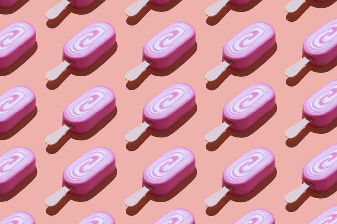 Many pink popsicles in a neat pattern on pink background