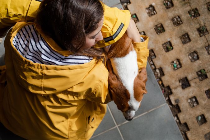 Woman holding a dog in street