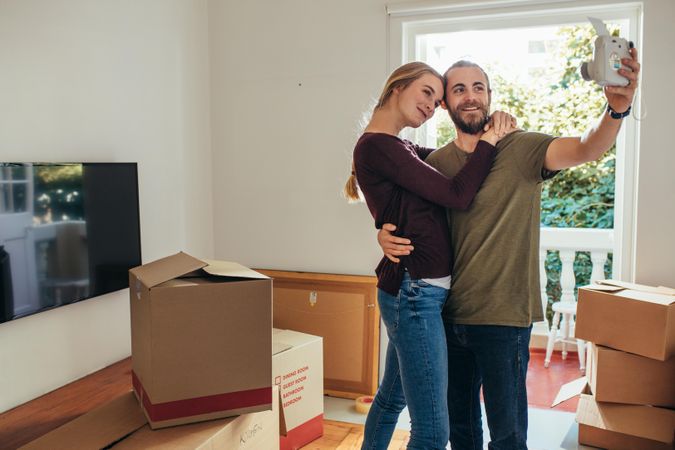 Young man and woman taking a selfie before moving out of home