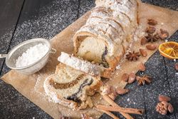 Sliced sponge cake and powdered sugar with whole spices on rustic table