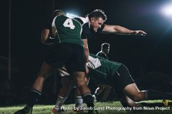 Rugby players competing in match under lights bGOlVb