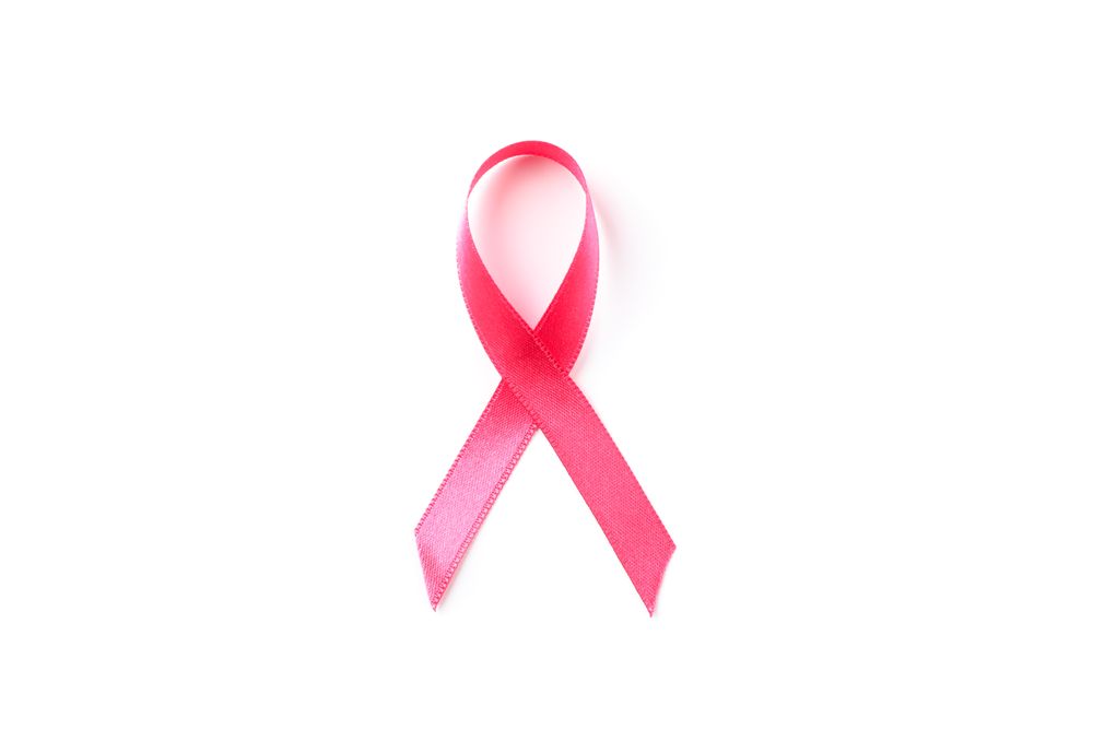 Pink awareness ribbon isolated on blank background, top view