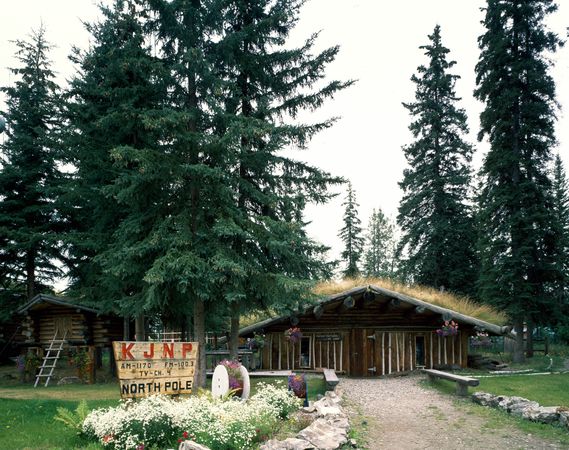 Rustic log cabin KJNP radio station building with pine trees