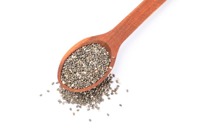 Chia seeds and wooden spoon isolated on plain background