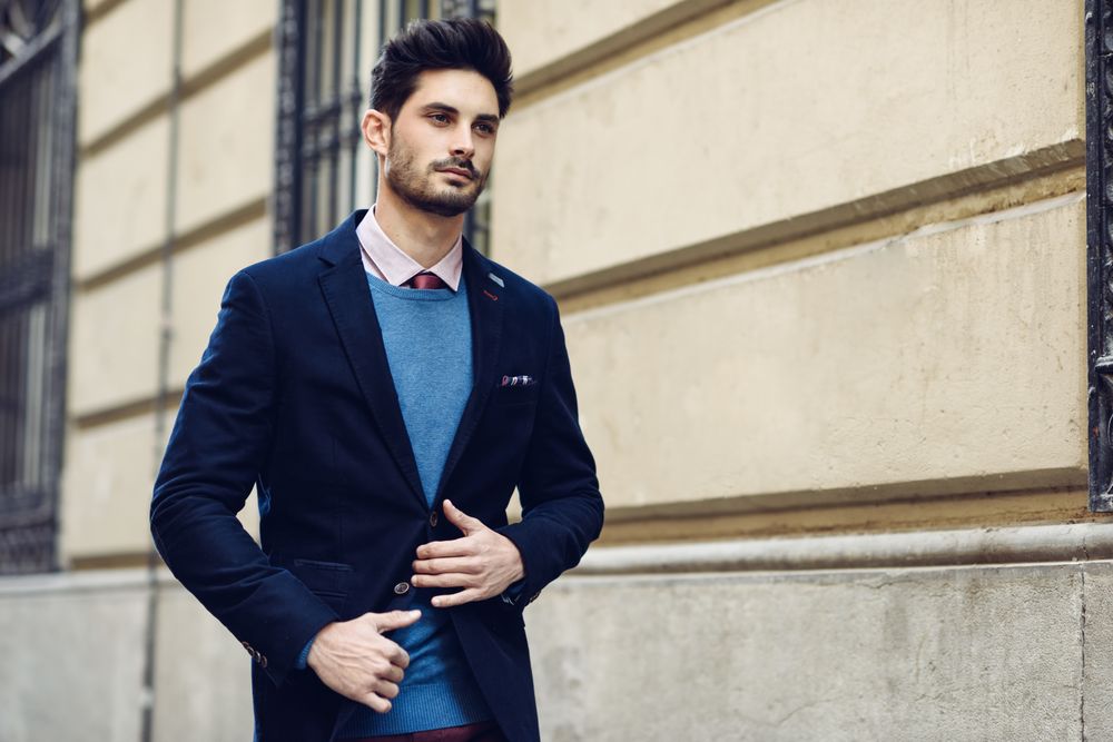 Attractive man in the street wearing elegant suit holding torso