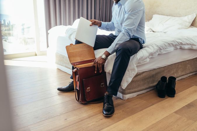Man sitting on his bed getting ready to go to office