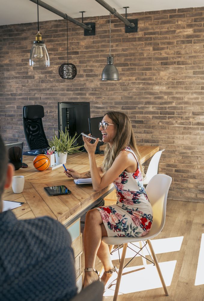Happy woman talking on the mobile in an office