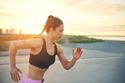 Muscular woman practicing sprints outside
