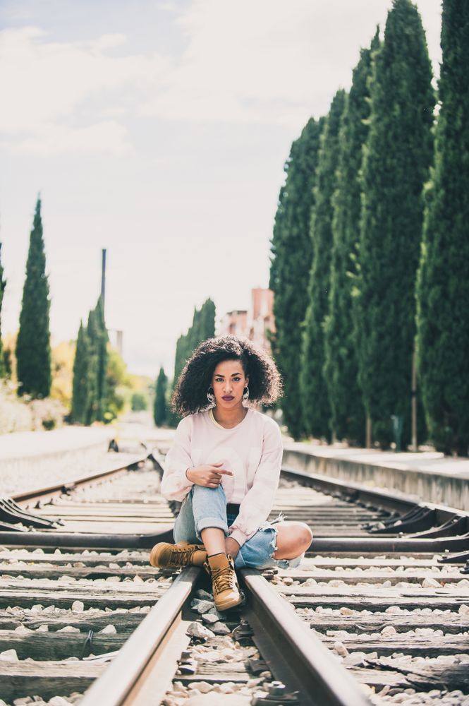 woman sitting in the tracks of a train