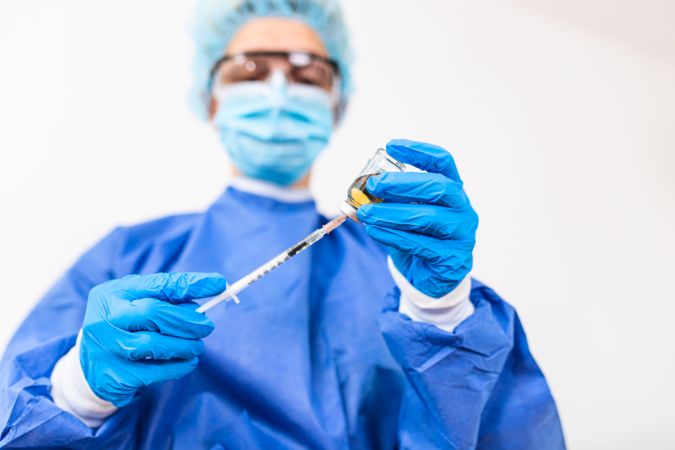 Doctor in PPE holding coronavirus vaccine
