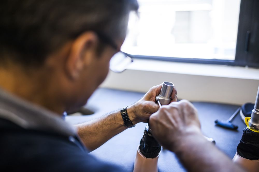 man fixing a prosthesis in a workshop