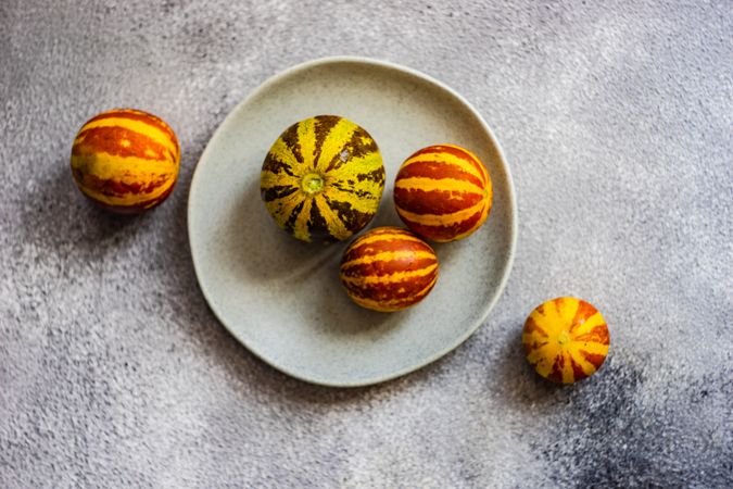 Top view of organic mini melons on grey plate