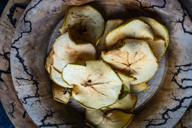 Dried apple chips in rustic bowl