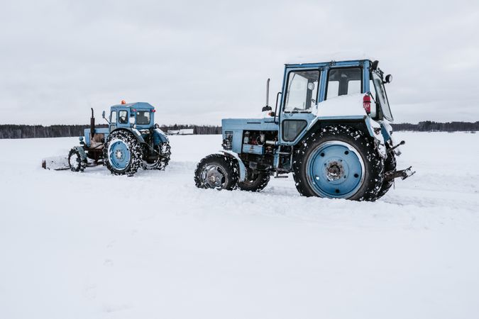 Tractors cleaning snow from field