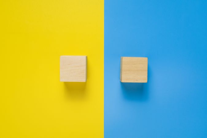 an empty wooden blocks isolated on blue and yellow background. copy space