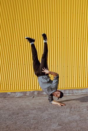 Man performing handstand near wall