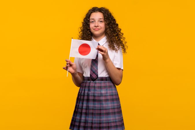 Girl holding Japanese flag in uniform
