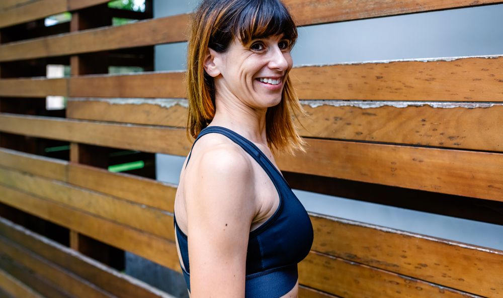 Cheerful female athlete in front of a wooden background