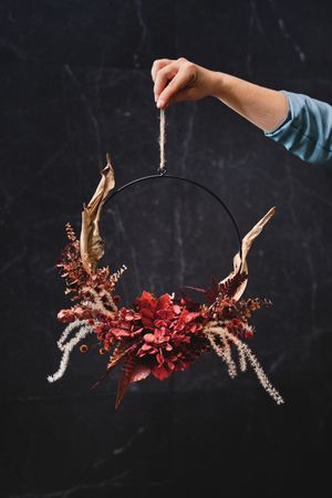 Crop person with dried floral wreath
