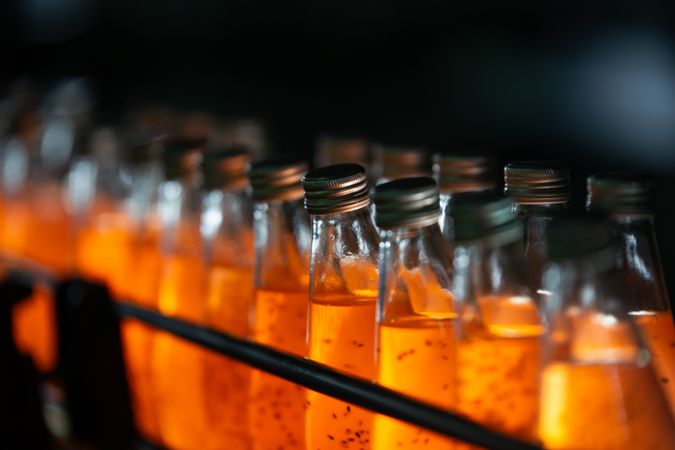 A row of water bottles moves along a conveyor belt on a beverage production line inside a factory.