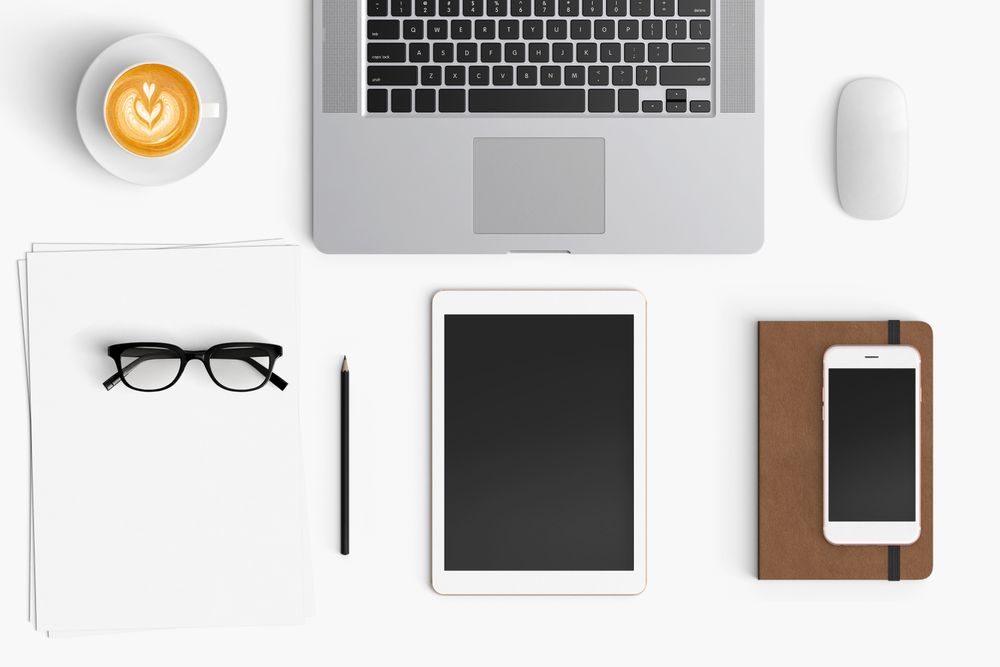 Modern workspace with coffee cup, smartphone, paper, notebook, tablet and laptop copy space